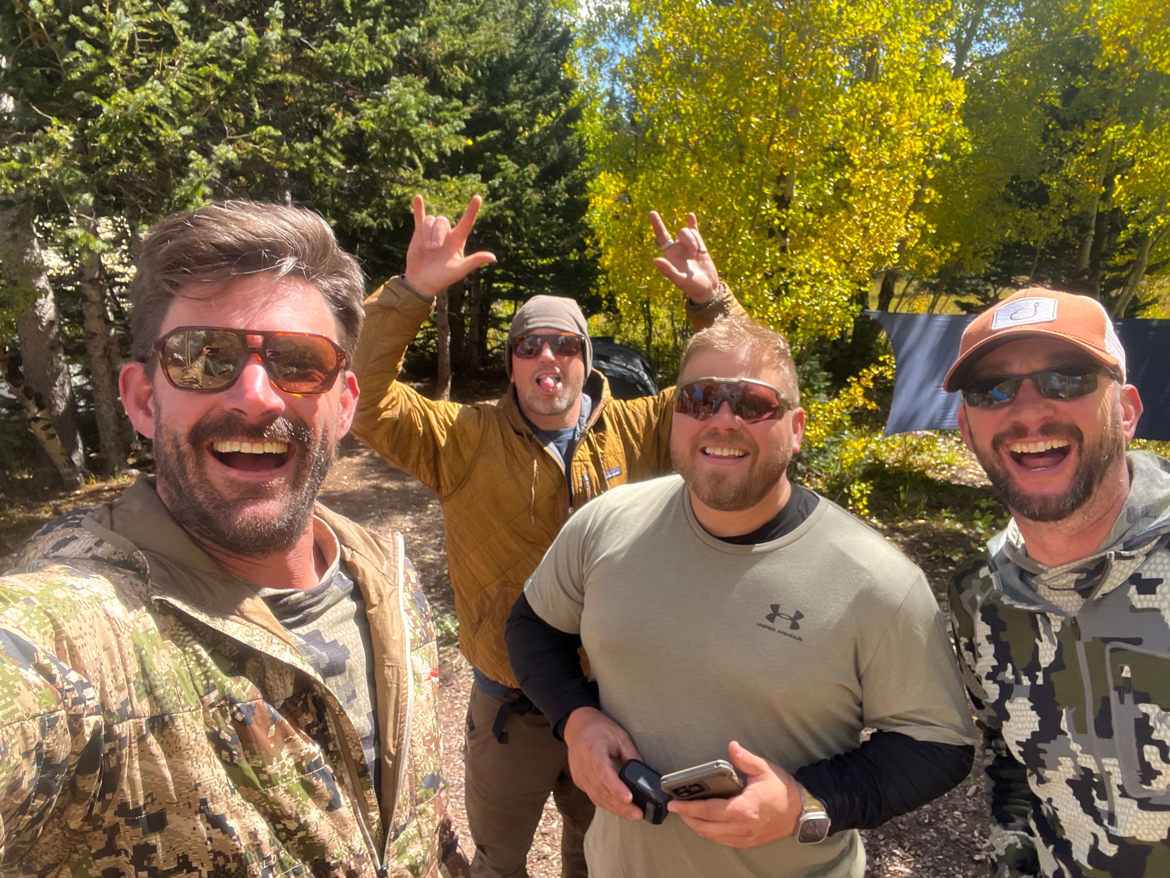 Four men in sunglasses with fall aspens behind them