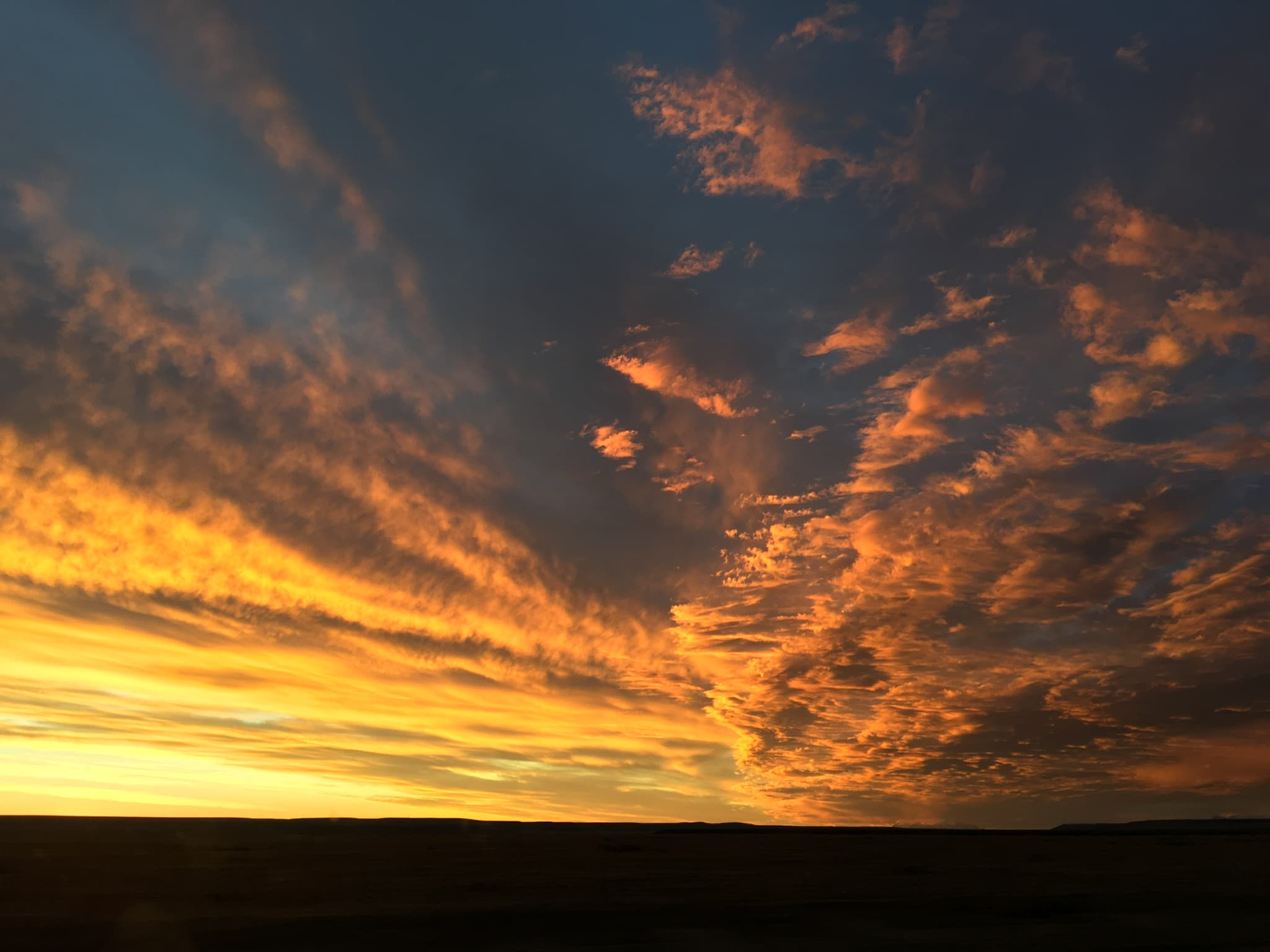 Wide prairie sunset with dramatic gold clouds