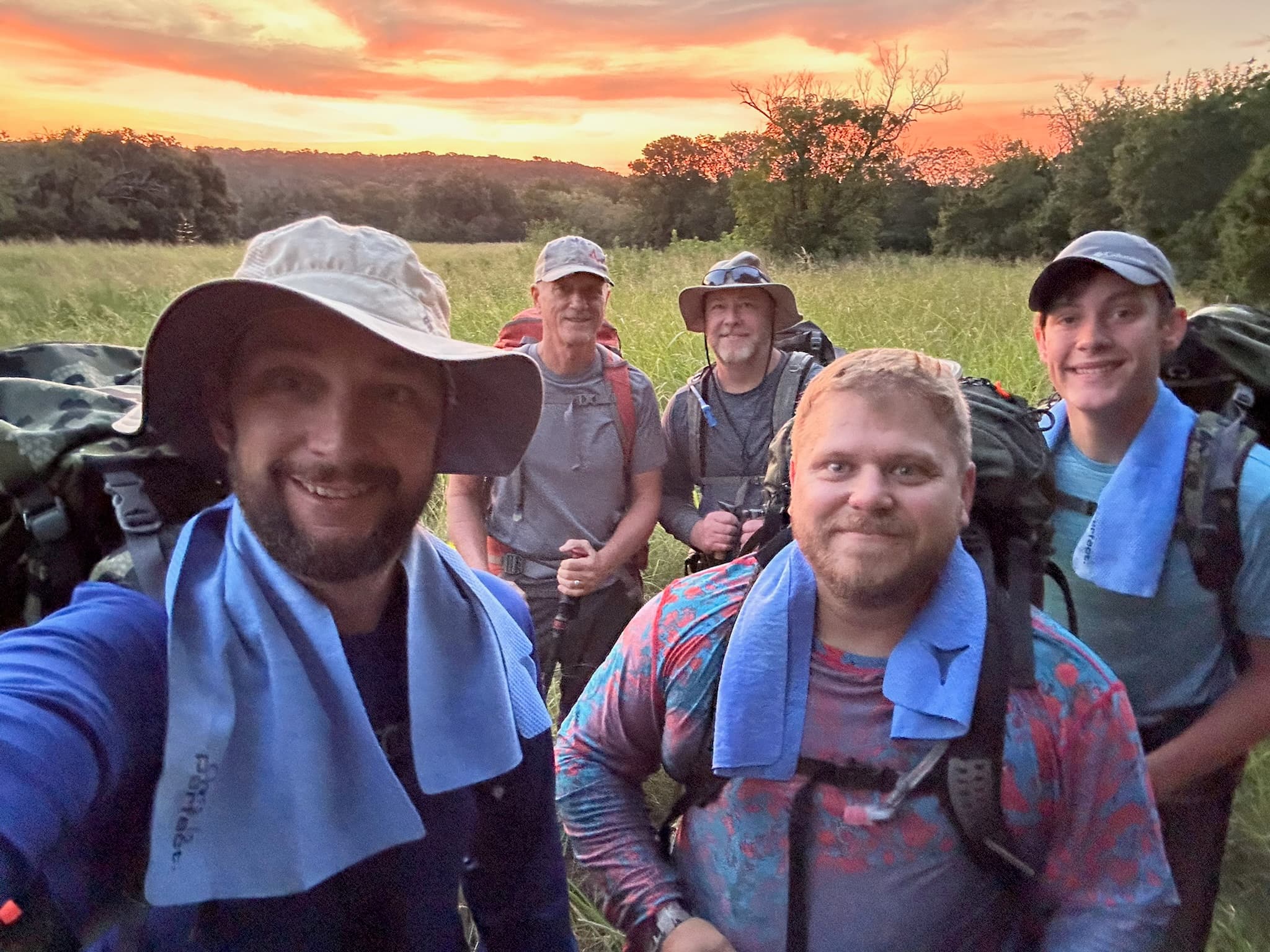Group of five with packs at sunrise on the prairie