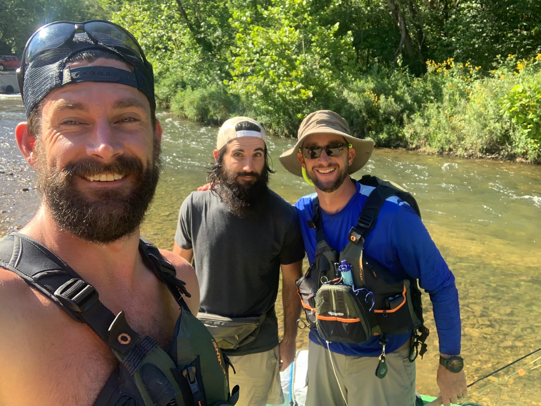 Three fly anglers streamside on a summer day