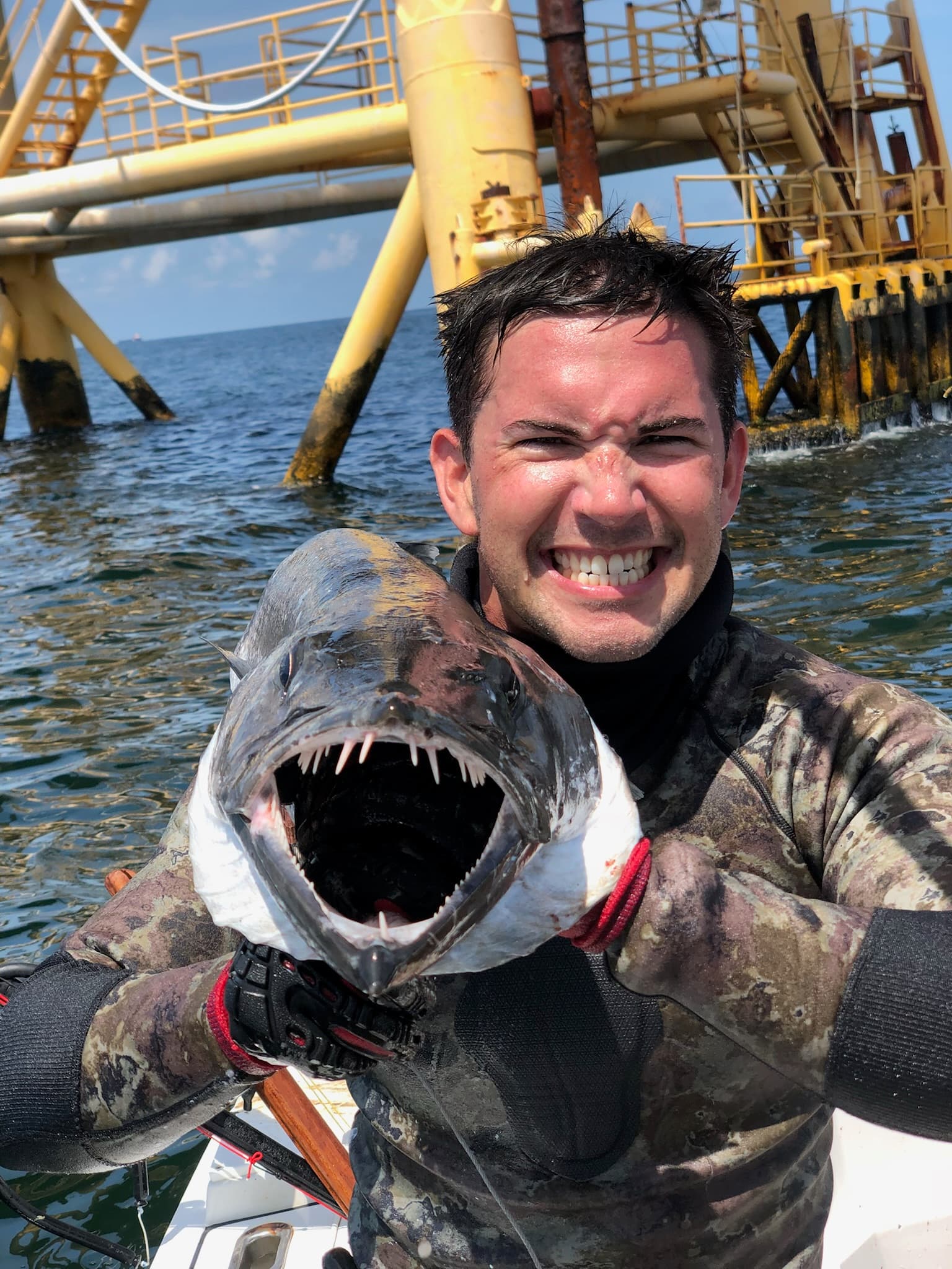 Spearfisher with a barracuda at an oil rig