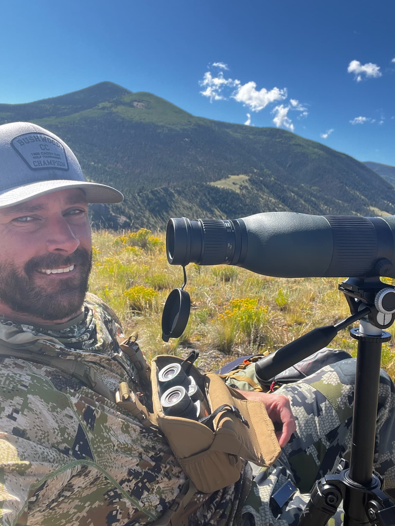 Hunter at a spotting scope in an alpine basin